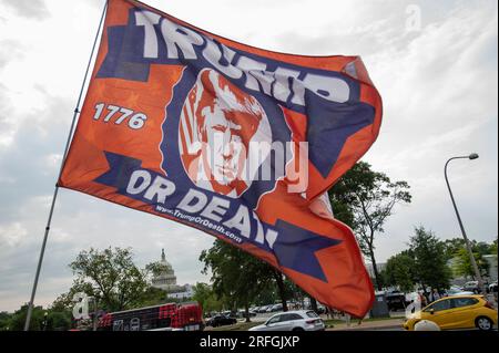 A trump supporter waves a flag as he walks along Constitution Avenue NW, outside the E. Barrett Prettyman United States Courthouse prior to the arrival of former US President Donald J. Trump for his arraignment in Washington, DC, Thursday, August 3, 2023. Former President Donald J. Trump is scheduled for an arraignment following his indictment by a grand jury, on four felony counts for his alleged efforts to overturn the 2020 election results. Credit: Rod Lamkey/CNP /MediaPunch Stock Photo