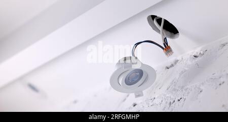 recessed lamp installation in drywall ceiling. led interior lighting. banner with copy space Stock Photo