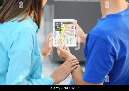 Couple of young tourists using tablet computer for navigation in city Stock Photo