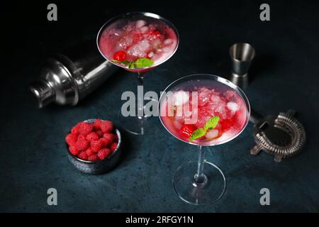 Glasses of fresh raspberry mojito and bowl with berries on blue table Stock Photo