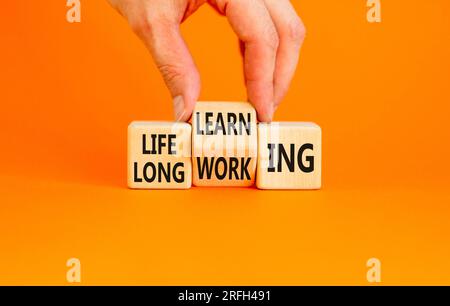 Lifelong learning working symbol. Concept word Lifelong learning working on block on a beautiful orange background. Businessman hand. Business educati Stock Photo