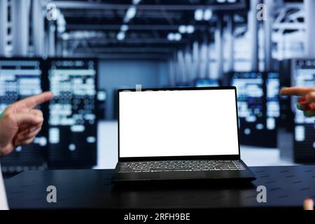 Close up shot of mock up laptop used by computer scientist in data center using server racks to deliver massive computing power, control network resources, process and store datasets Stock Photo