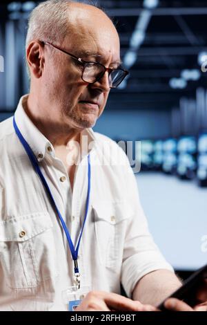 IT developer coding in server farm using javascript language. Proficient professional updating software on data center supercomputers on laptop terminal, ensuring optimal performance and security Stock Photo