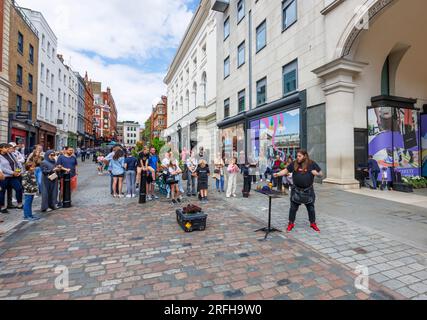 Australian street magician Jason Maher performs and entertains a crowd in Covent Garden in London's West End, WC2 Stock Photo