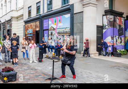 Australian street magician Jason Maher performs and entertains a crowd in Covent Garden in London's West End, WC2 Stock Photo