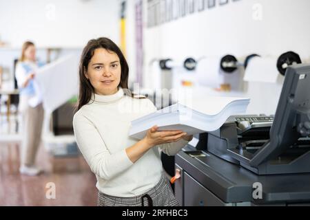 Technician working on plotter and cutter machine in printing shop Stock Photo
