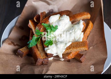 fried black bread, croutons with creamy garlic sauce, food a quick snack in a cafe Stock Photo