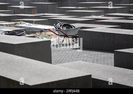 Berlin, Germany. 03rd Aug, 2023. View of a wheelbarrow at the Memorial to the Murdered Jews of Europe. Many of the more than 2700 concrete stelae of the Holocaust Memorial near the Brandenburg Gate show cracks. Credit: Hannes P. Albert/dpa/Alamy Live News Stock Photo