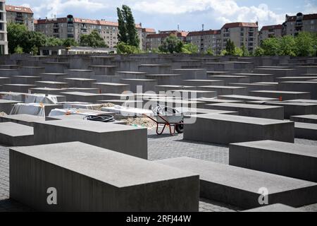 Berlin, Germany. 03rd Aug, 2023. View of a wheelbarrow at the Memorial to the Murdered Jews of Europe. Many of the more than 2700 concrete stelae of the Holocaust Memorial near the Brandenburg Gate show cracks. Credit: Hannes P. Albert/dpa/Alamy Live News Stock Photo