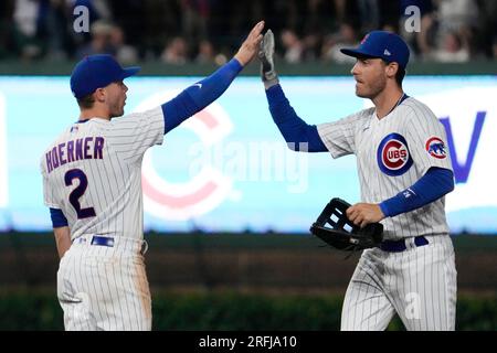 Chicago Cubs' Seiya Suzuki, left, is congratulated by first base coach Mike  Napoli after hitting a single against the San Francisco Giants during the  eighth inning of a baseball game in San