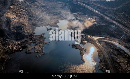 Work of trucks and the excavator in an open pit on gold mining, soft focus Stock Photo