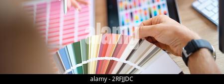 Client chooses color from variety of samples in art studio close up. Stock Photo