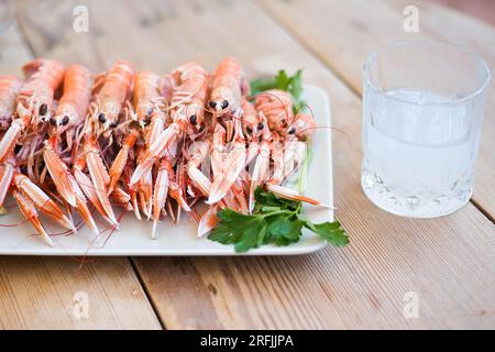 crayfish boiled in pot, ready to eat, on plate on wooden table, very tasty and aphrodisiac seafood Stock Photo