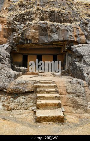 Vertical view of Facade near Cave 12 Vihara showing Stairs, three Cell Doors with rock-cut at Bhaja Caves, Ancient Buddhist built in 2nd century BC, d Stock Photo