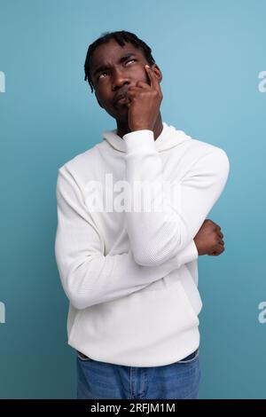 smart dark-skinned young brunette man solves a problem in his head Stock Photo