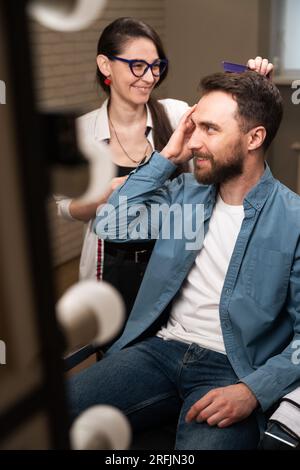 Barber woman at the workplace communicates with a client Stock Photo