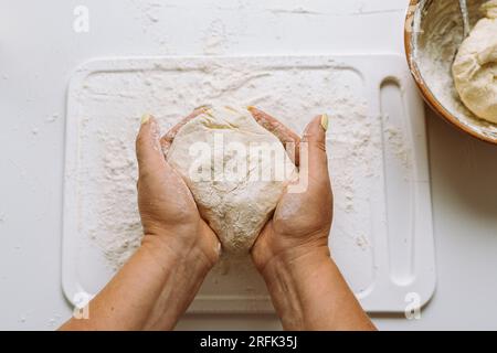 Female hands knead dough Stock Photo