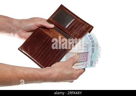 Men's hand holding leather wallet and ukrainian currency isolated on white background. Brown wallet with money in male hands Stock Photo