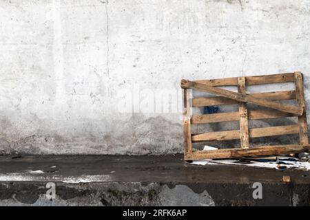 A wooden pallet stands leaned against the wall in the loading area Stock Photo