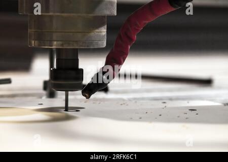 End mill processes a detail on a CNC milling machine, close-up photo with selective soft focus Stock Photo