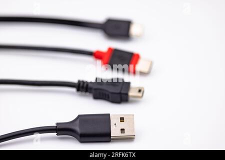 Mini USB connector and cable alongside other USB type adapters isolated in studio against white background Stock Photo