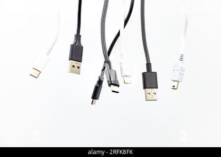 Chaos with different USB type plugs and standards isolated in the studio against a white background Stock Photo