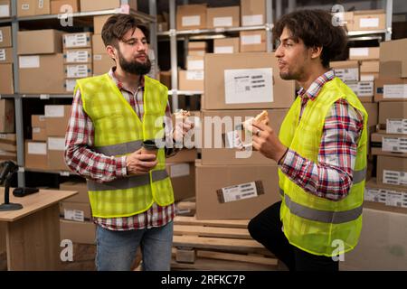 Warehouse workers having a lunch break resting eat and talk Stock Photo