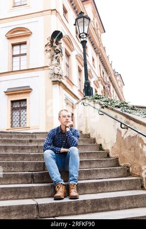 man in shirts and blue jeans walks on streets of autumn Praga Stock Photo