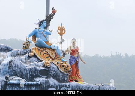 Giant statue of Lord Shiva and Parvati at Triveni Ghat, Rishikesh, with Lord Shiva sitting on the back of a tiger and Goddess Ganga. Stock Photo