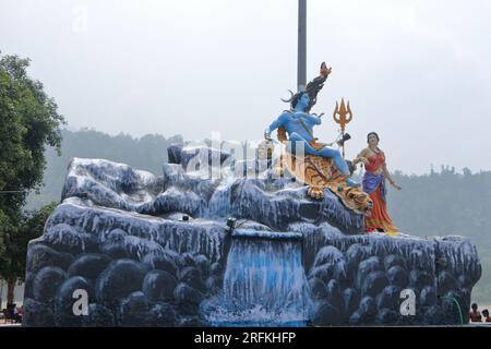 Giant statue of Lord Shiva and Parvati at Triveni Ghat, Rishikesh, with Lord Shiva sitting on the back of a tiger and Goddess Ganga. Stock Photo