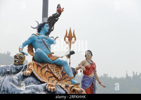 Giant statue of Lord Shiva and Parvati at Triveni Ghat, Rishikesh, with Lord Shiva sitting on the back of a tiger and Goddess Ganga. Stock Photo