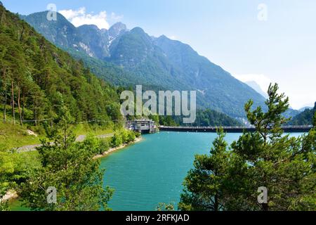 View of Lago di Cadore lake in Veneto region and Belluno province in Italy and a hydroelectric power plant and mountains rising above the lake Stock Photo