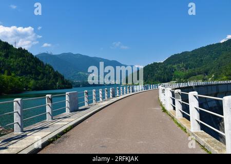 Road leading across Pieve di Cadore dam at Lago di Cadore in Veneto region and Belluno province in Italy and Dolomite Mountains Stock Photo