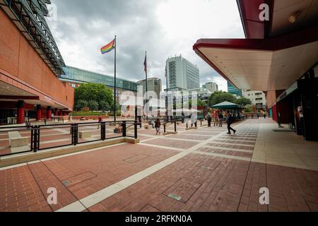 London, England, UK - July 31, 2022. British Library building exterior grounds entrance, with people, a progress pride flag waving from the flag pole. Stock Photo