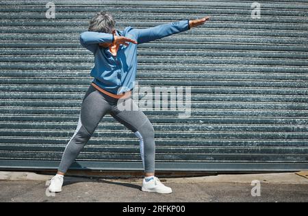 Woman, fitness and dab dance outdoor at training, exercise or workout achievement with celebration. Mature runner lady, comic dancing and winner in Stock Photo