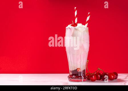 Sweet homemade cherry-cola milkshake with whipped cream, ice cream, cold cola, fresh cherries and syrup Stock Photo