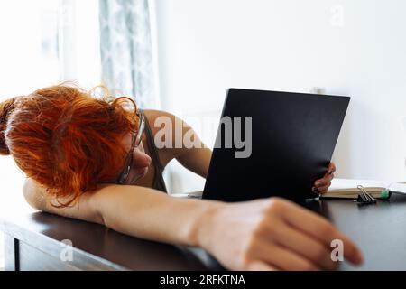 Tired teenager girl studying using computer at home Stock Photo