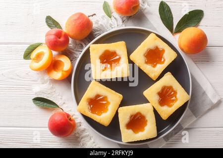 Tasty summer soft cookies Cuor di tenerezza with apricot jam close-up on a plate on the table. Horizontal top view from above Stock Photo