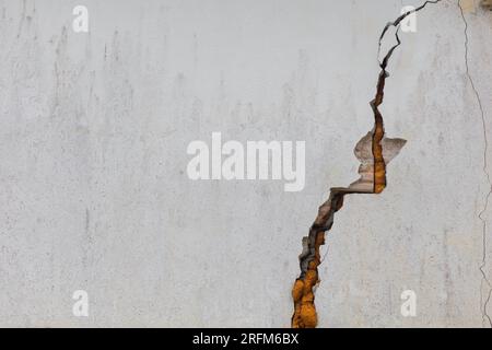 Cracked white cement walls indicate insecurity and repairs. Stock Photo