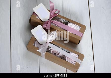 Homemade marshmallows in paper gift boxes. Zephyr flowers. The boxes are tied with a ribbon tied into a bow. Stock Photo