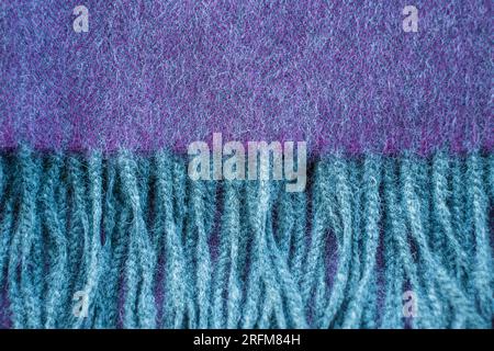 Close-up of soft alpaca wool scarf details. Gray and purple herringbone knit pattern shawl. Stock Photo