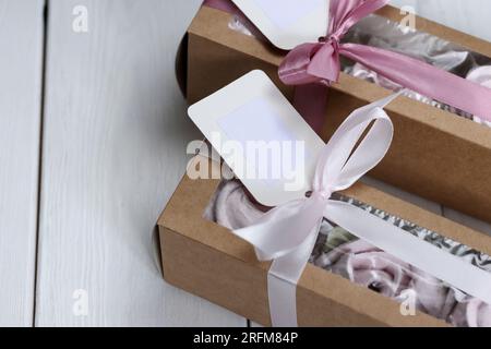 Homemade marshmallows in paper gift boxes. Zephyr flowers. The boxes are tied with a ribbon tied into a bow. Stock Photo