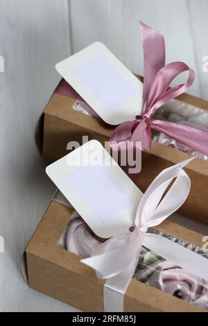 Homemade marshmallows in paper gift boxes. Zephyr flowers. The boxes are tied with a ribbon tied into a bow. Stock Photo