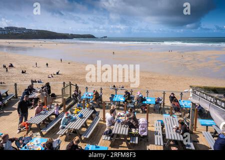Holidaymakers relaxing socialising on the outdoor decking area of the Fistral Beach Bar in Newquay in Cornwall in England in the UK. Stock Photo