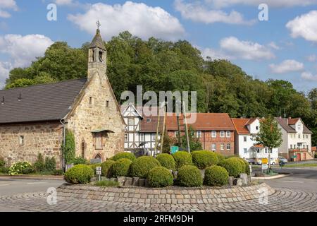 Hospital chapel of the Holy Ghost and fountain sculpture 'Der Brunnen der Verwunschenen' by Carin Grudda on roundabout in town Gudensberg, Germany Stock Photo