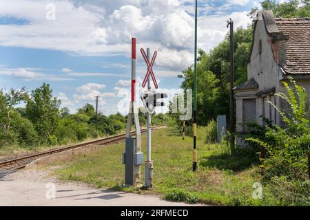 Abandoned railway station with light barrier and rails in Hungary Stock Photo