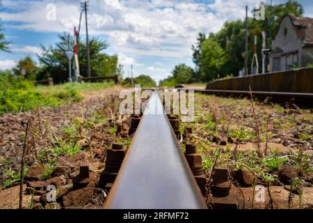 Abandoned railway station with light barrier and rails in Hungary Stock Photo