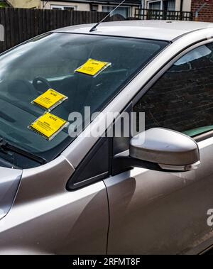 Multiple Parking Tickets or Penalty Charge Notices on the windscreen of a car parked in the street Stock Photo