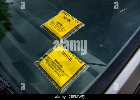 Multiple Parking Tickets or Penalty Charge Notices on the windscreen of a car parked in the street Stock Photo