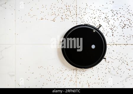 Robotic vacuum cleaner on white tile floor smart cleaning technology. Stock Photo